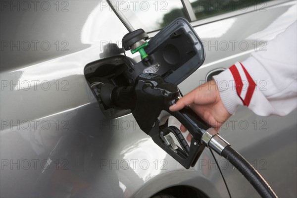 Human hand holding refueling pump. Photo : fotog