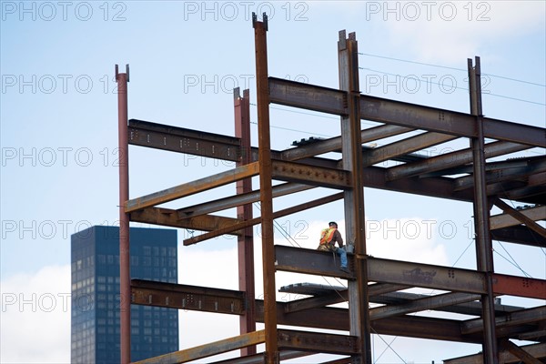 USA, New York City, Construction worker sitting on unfinished structure. Photo : fotog