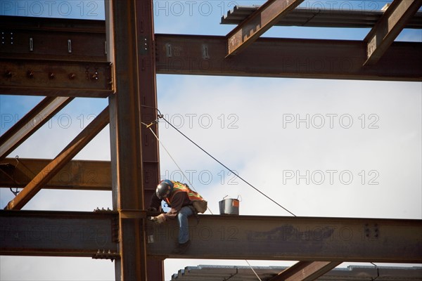 Construction worker working on unfinished structure. Photo : fotog