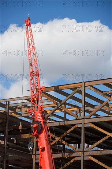 Unfinished structure and crane at construction site. Photo : fotog