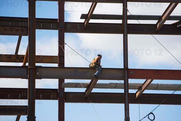 Construction worker working on unfinished structure. Photo : fotog