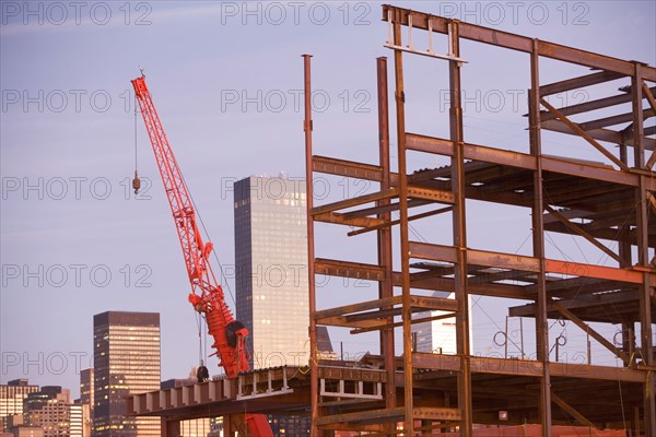 USA, New York City, Crane with unfinished structure and Manhattan skyline in background. Photo : fotog