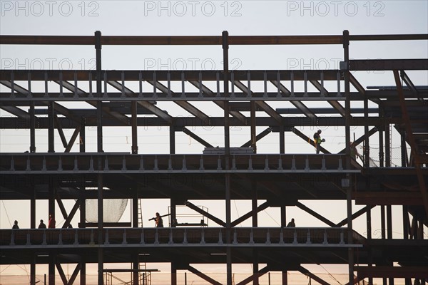 Group oaf construction workers working on unfinished structure. Photo : fotog