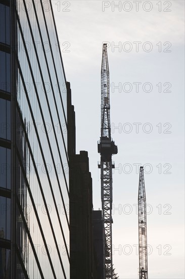 USA, New York City, Modern office building and cranes in background. Photo: fotog
