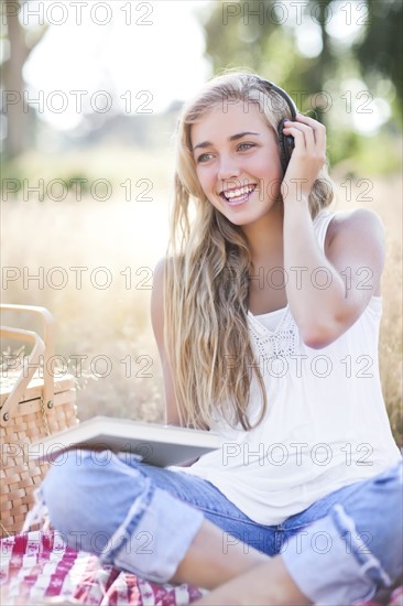 Teenage girl (16-17) posing with book and headphones on. Photo: Take A Pix Media