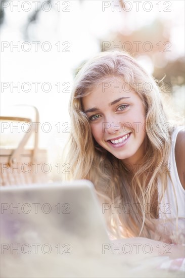 Teenage girl (16-17) posing with laptop outdoors. Photo : Take A Pix Media