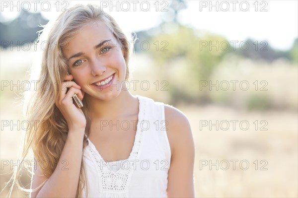 Teenage girl (16-17) using mobile phone outdoors. Photo: Take A Pix Media