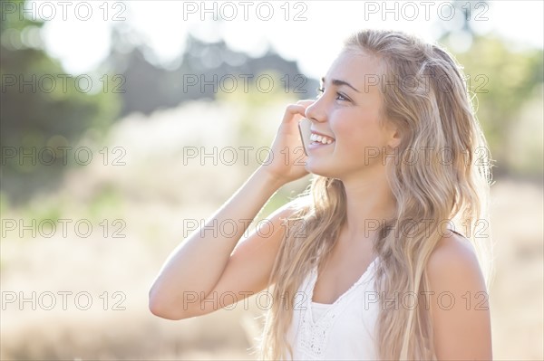 Teenage girl (16-17) using mobile phone outdoors. Photo: Take A Pix Media