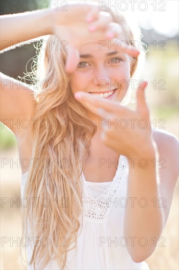 Teenage girl (16-17) displaying finger frame. Photo: Take A Pix Media