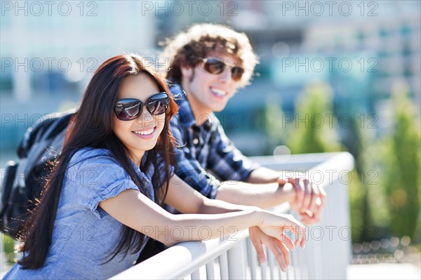Couple standing by banister outdoors. Photo : Take A Pix Media