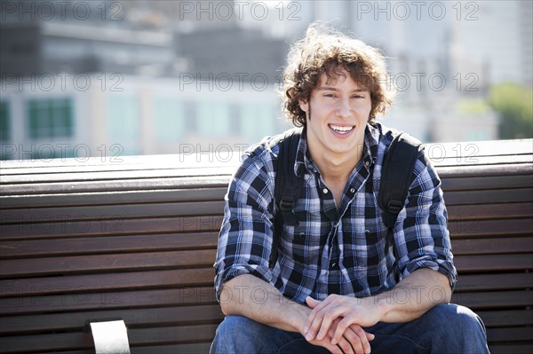 USA, Washington, Seattle, Young man sitting on bench. Photo : Take A Pix Media