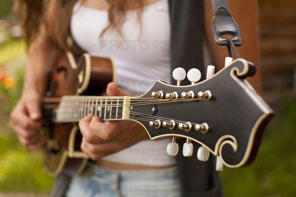 Midsection of woman playing guitar. Photo : John Kelly