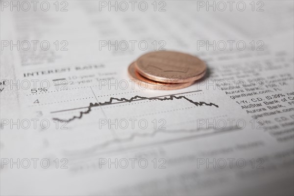 Studio shot of coins on financial newspaper. Photo : Winslow Productions