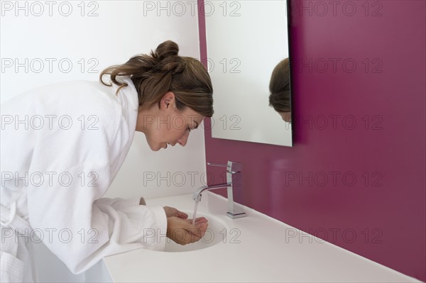 Woman washing hands in bathroom. Photo : Jan Scherders