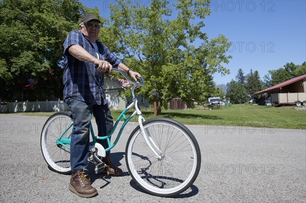 USA, Montana, Whitefish, Portrait of senior man on bike. Photo: Noah Clayton