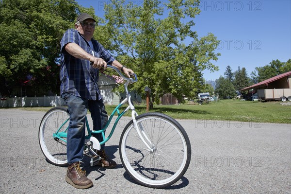 USA, Montana, Whitefish, Portrait of senior man on bike. Photo : Noah Clayton