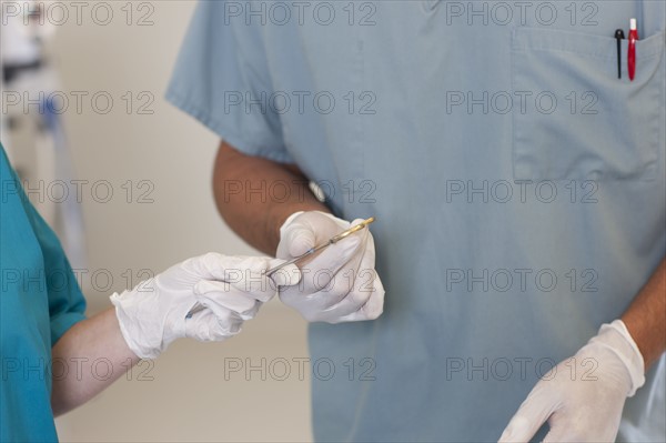 Midsection of surgeons holding tools. Photo: db2stock