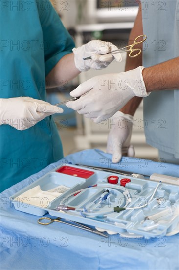 Midsection of surgeons holding tools. Photo: db2stock