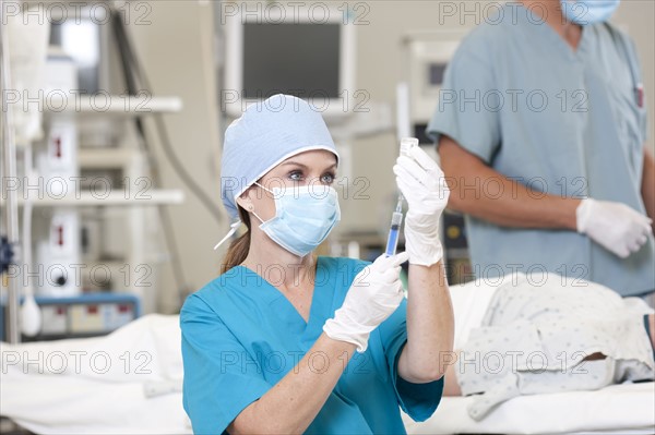 Surgeons preparing patient for surgery. Photo : db2stock