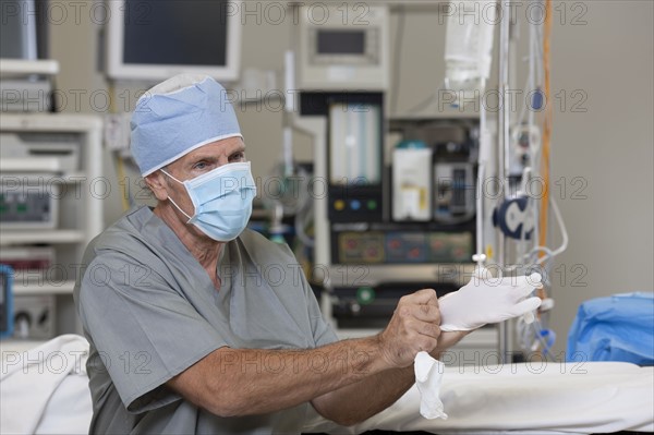 Surgeon putting on gloves. Photo: db2stock