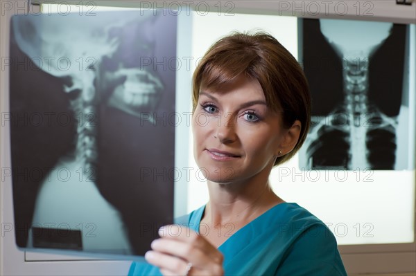 Portrait of female doctor looking at x-ray. Photo : db2stock