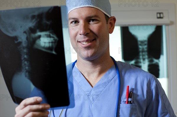 Portrait of male doctor looking at x-ray. Photo : db2stock