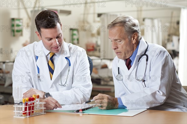 Two doctors reading medical document in hospital. Photo: db2stock