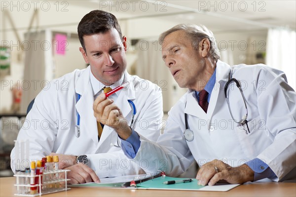 Two doctors examining test tube in hospital. Photo: db2stock