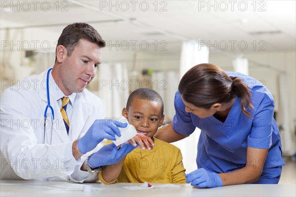 Doctors applying bandage on boy's (4-5) hand. Photo: db2stock