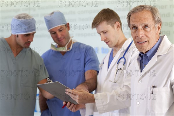 Doctors and surgeons discussing on medical record. Photo: db2stock