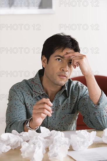 Businessman with crumpled paper balls. Photo : Rob Lewine