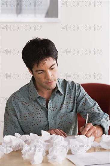 Businessman with crumpled paper balls. Photo : Rob Lewine