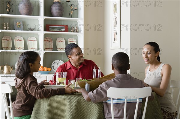 Parents and children (10-13) eating dinner together. Photo : Rob Lewine