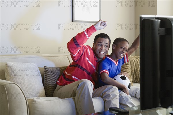 Father and Son (12-13) watching sports on tv. Photo: Rob Lewine