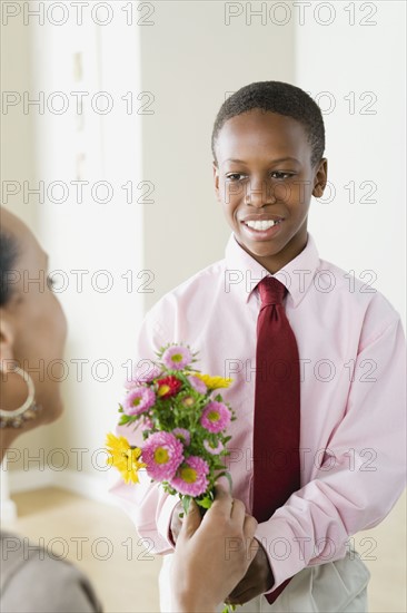 Son (12-13) giving flowers to Mother. Photo : Rob Lewine