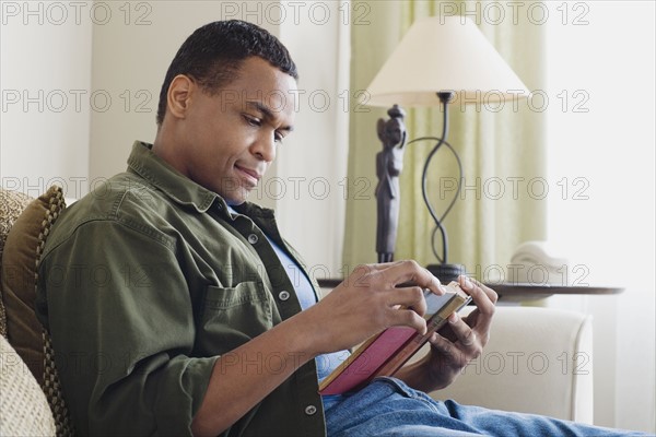 Man reading book at home. Photo : Rob Lewine