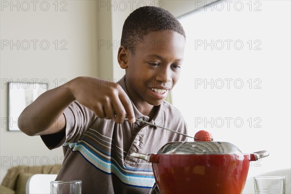 Boy (12-13) preparing dessert. Photo: Rob Lewine