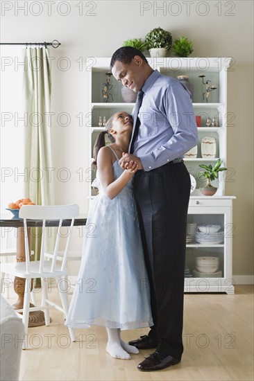 Father and Daughter (10-11) dancing in kitchen. Photo : Rob Lewine