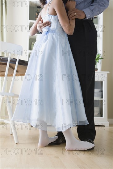 Low section of Father and Daughter (10-11) dancing in kitchen. Photo: Rob Lewine