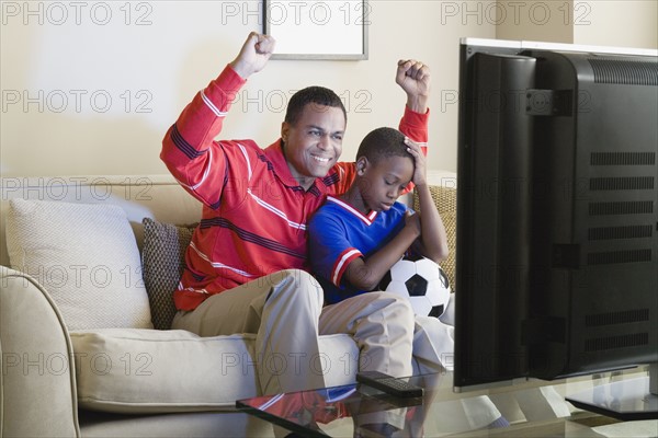 Father and Son (12-13) watching sports on tv. Photo: Rob Lewine