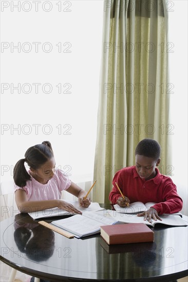 Brother and sister (12-13) doing homework. Photo: Rob Lewine