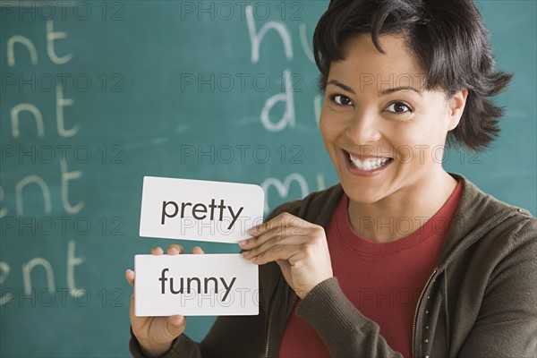 Portrait of female teacher holding text tags. Photo : Rob Lewine