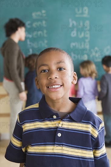 Portrait of boy (6-7) with schoolmates in background. Photo : Rob Lewine