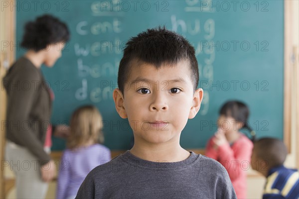 Portrait of boy (6-7) with schoolmates in background. Photo : Rob Lewine