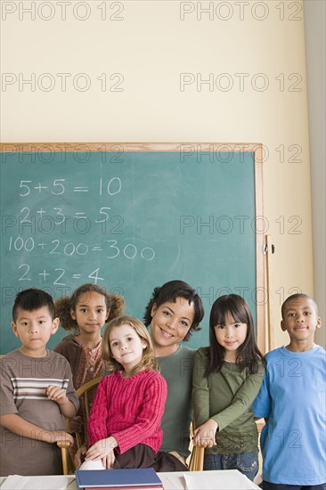 Teacher with children (6-7) at school looking at camera. Photo : Rob Lewine