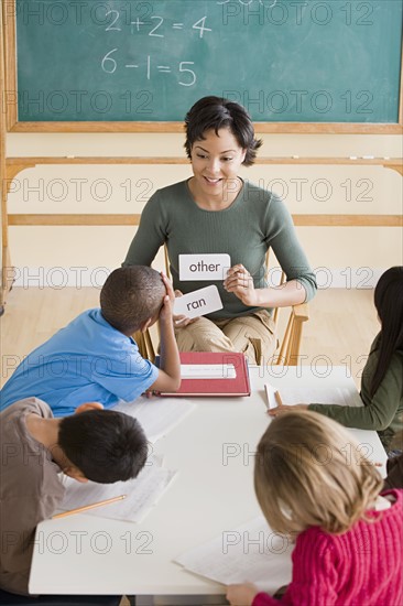 Female teacher with pupils (6-7) in classroom. Photo : Rob Lewine