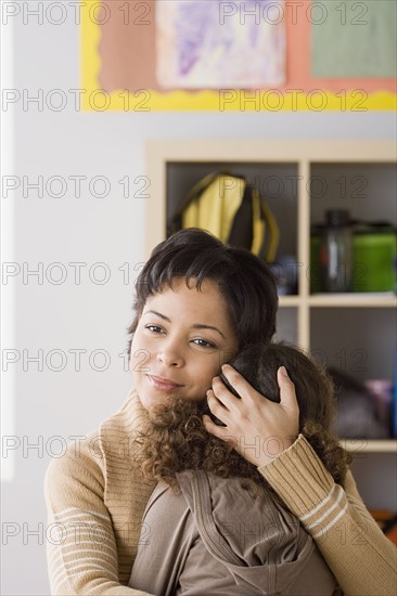 Teacher comforting girl (6-7). Photo : Rob Lewine