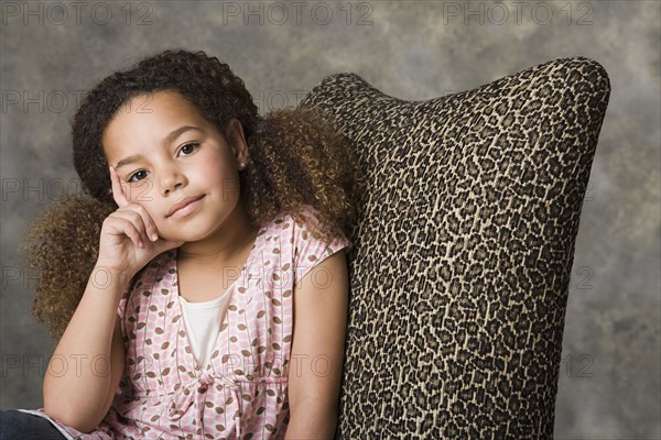 Portrait of thoughtful girl (8-9) sitting, studio shot. Photo : Rob Lewine