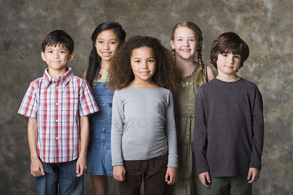 Children (6-7, 8-9) posing together, studio shot. Photo: Rob Lewine