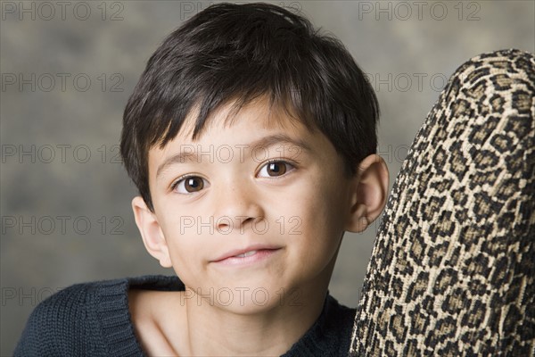 Portrait of smiling boy (8-9) looking at camera, studio shot. Photo: Rob Lewine